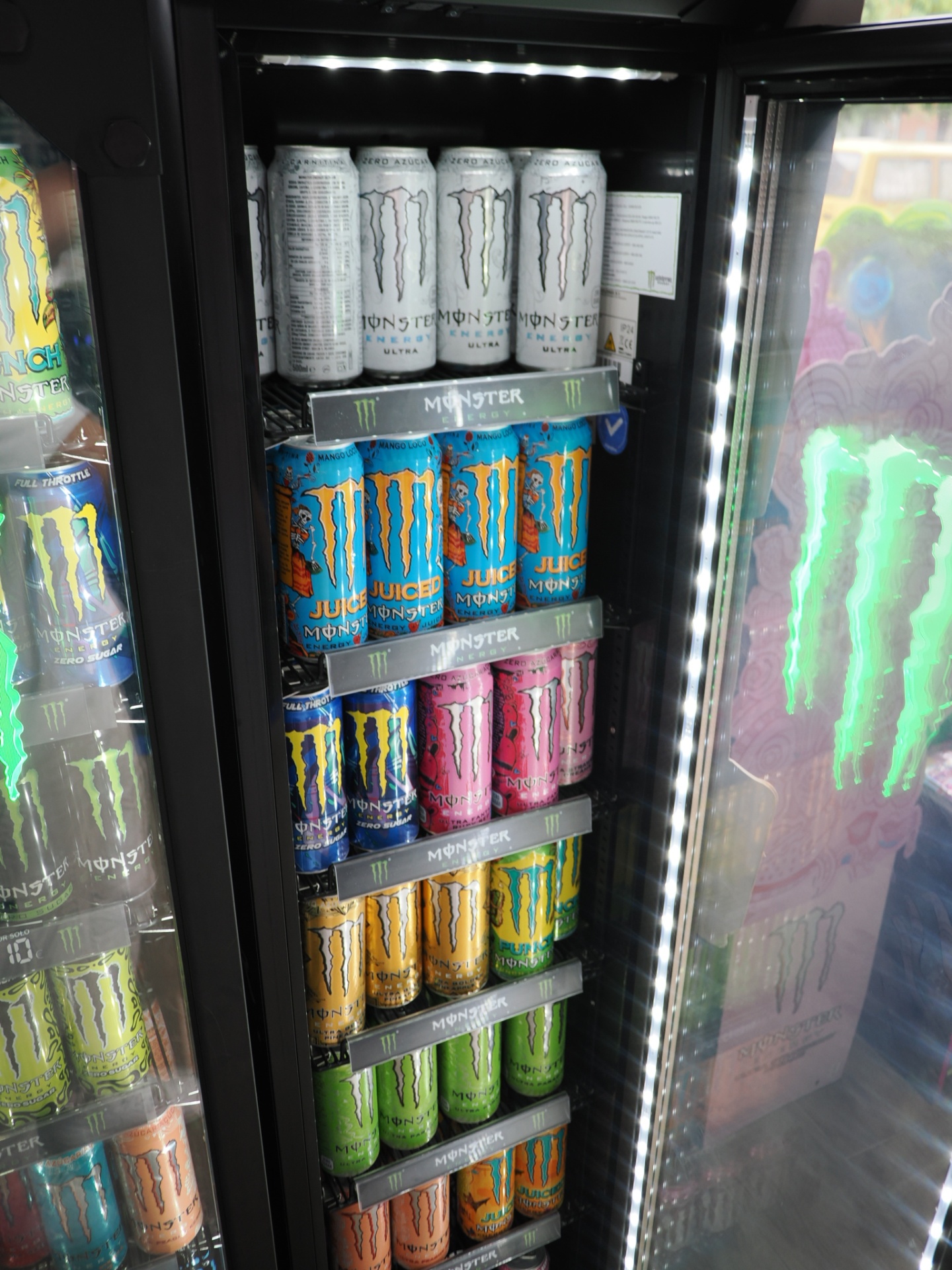 Nevera con latas de Monster Energy en múltiples sabores