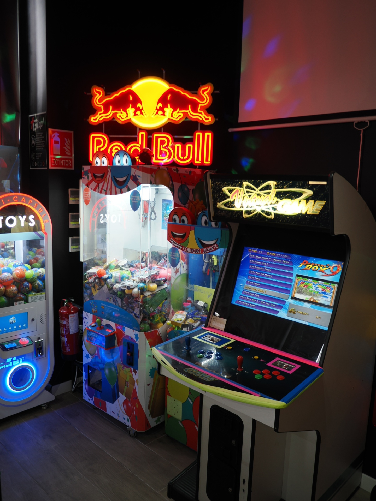 Máquina recreativa y peluchera bajo el neón de Red Bull